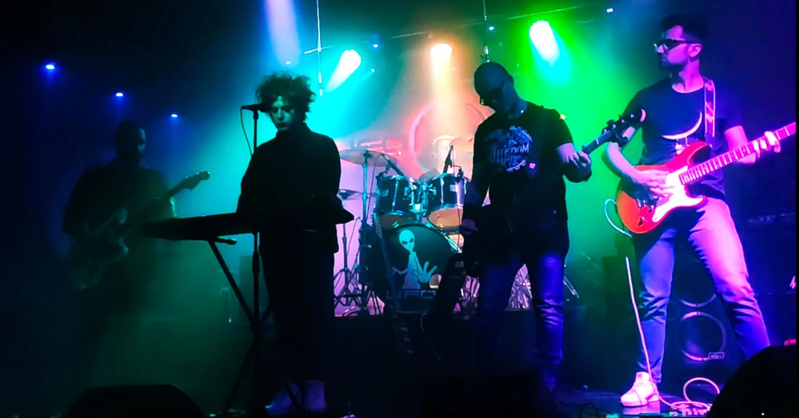 Just One Kiss live on stage under coloured lights